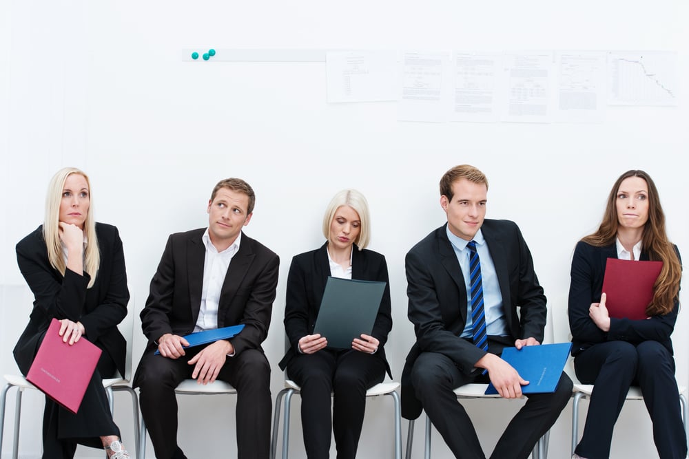 Group of applicants for a vacant post or corporate job sitting in a long line with folders containing their credentials carefully ignoring each other
