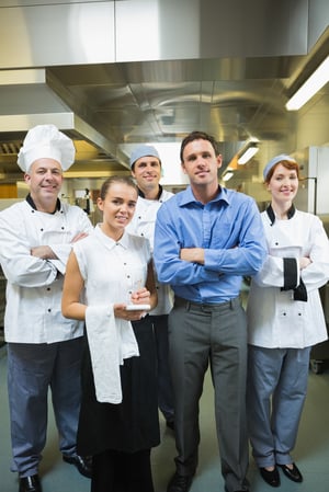 Restaurant team posing together in a kitchen